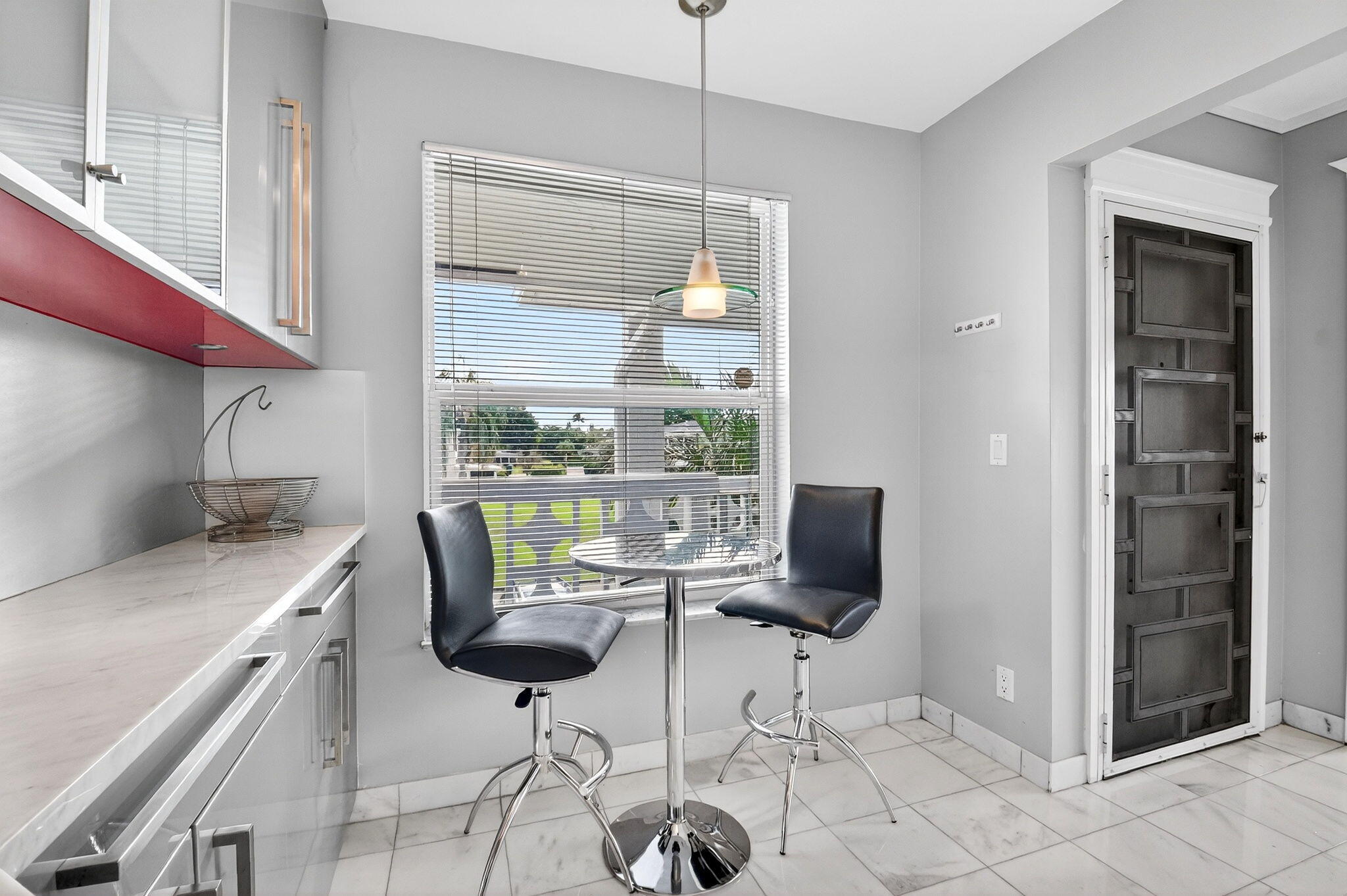 1411 Southwest 27th Avenue, Unit 201 Delray Beach, FL 33445 - Photo 14 of 48 a kitchen with stainless steel appliances kitchen island granite countertop a table and chairs in it