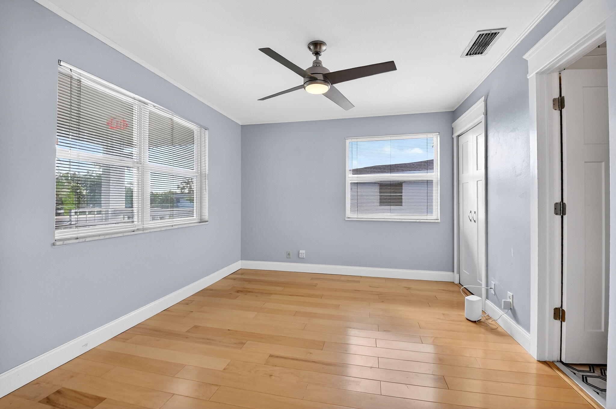 1411 Southwest 27th Avenue, Unit 201 Delray Beach, FL 33445 - Photo 23 of 48 a view of an empty room with wooden floor and a window