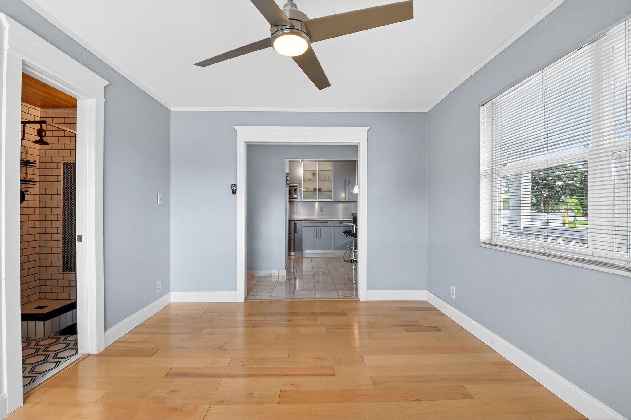 1411 Southwest 27th Avenue, Unit 201 Delray Beach, FL 33445 - Photo 24 of 48 a view of an empty room with wooden floor and a window
