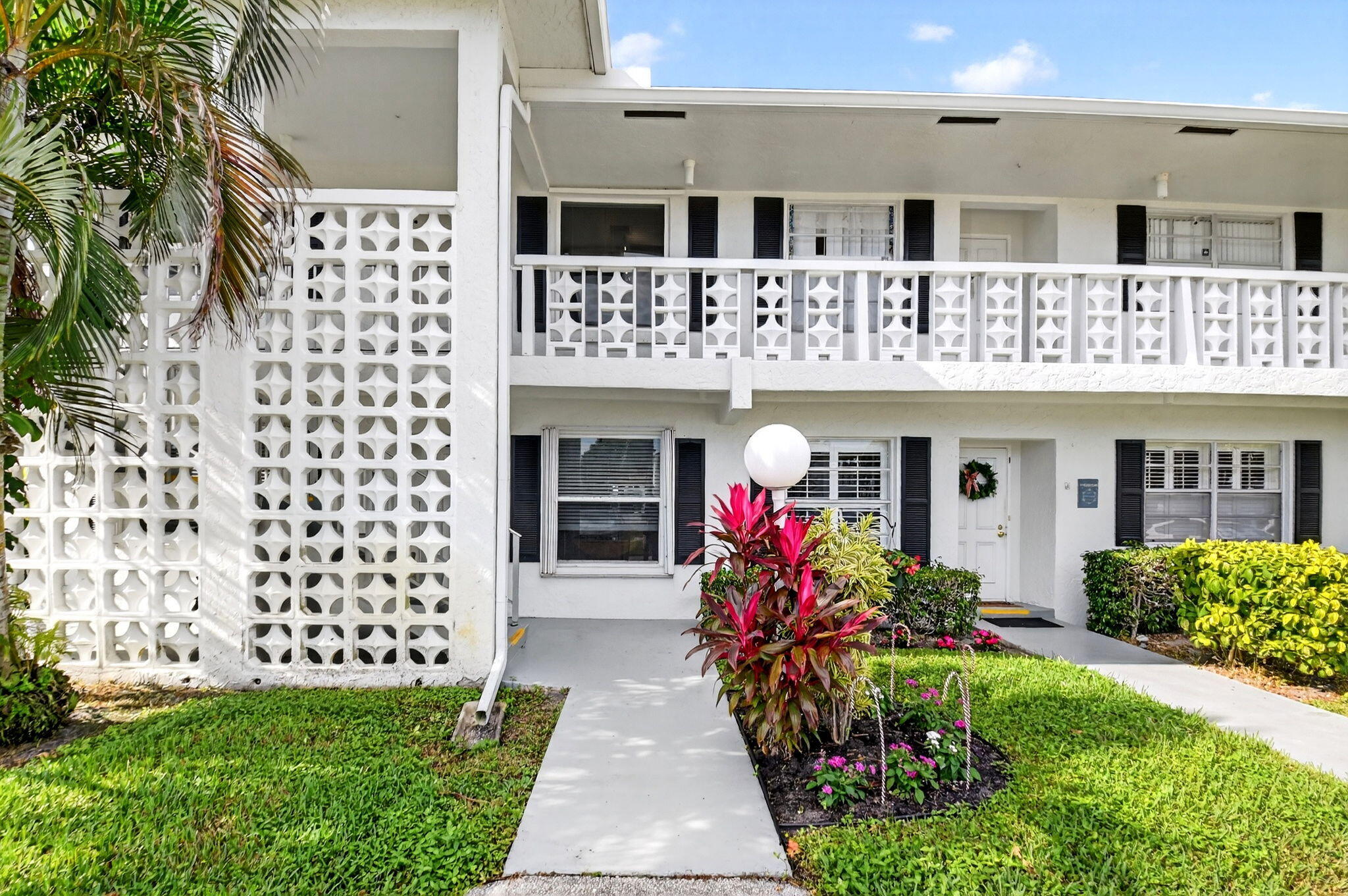 1411 Southwest 27th Avenue, Unit 201 Delray Beach, FL 33445 - Photo 3 of 48 a front view of a house with a porch