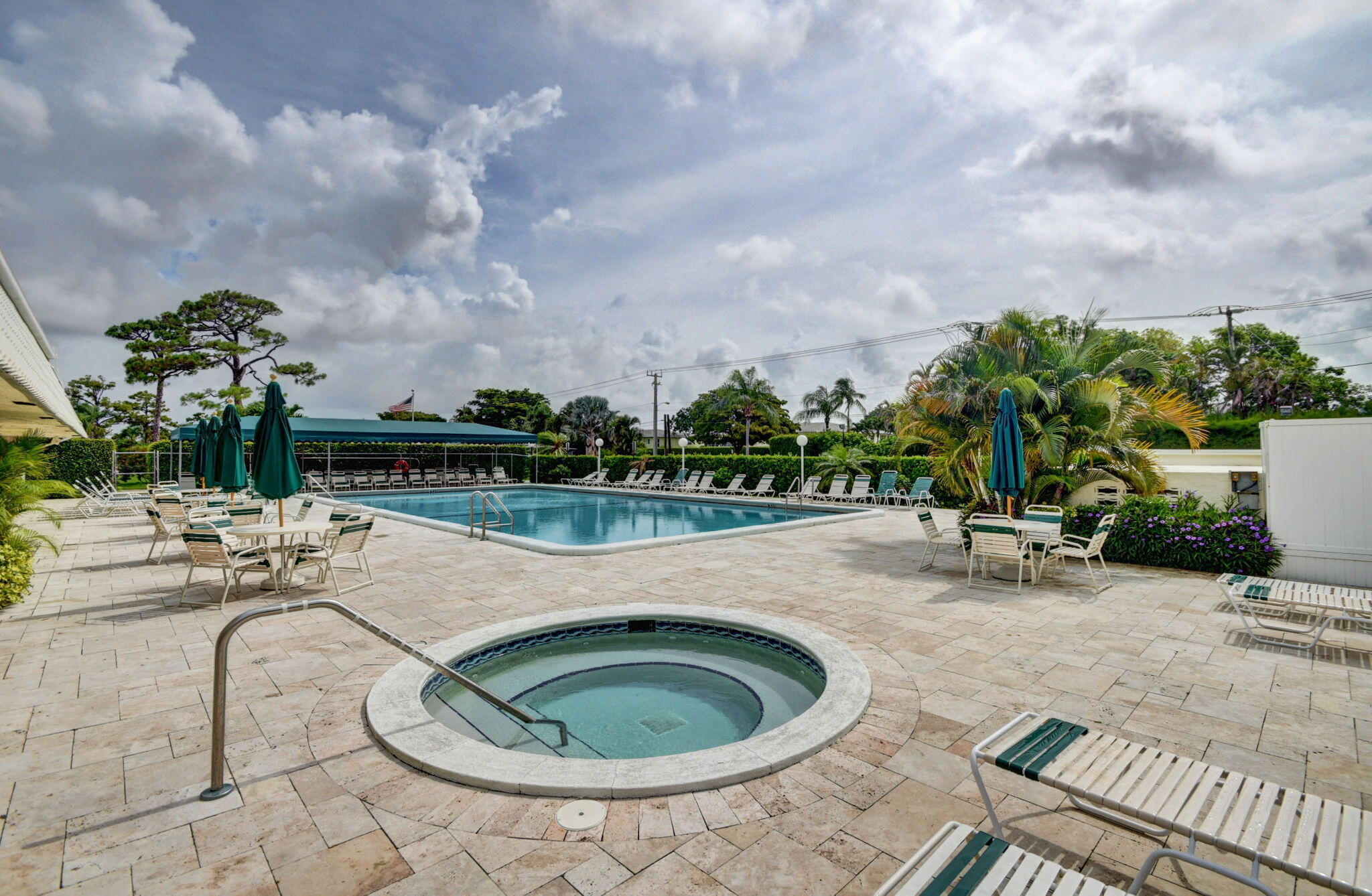 1411 Southwest 27th Avenue, Unit 201 Delray Beach, FL 33445 - Photo 40 of 48 a view of a swimming pool with outdoor seating and plants