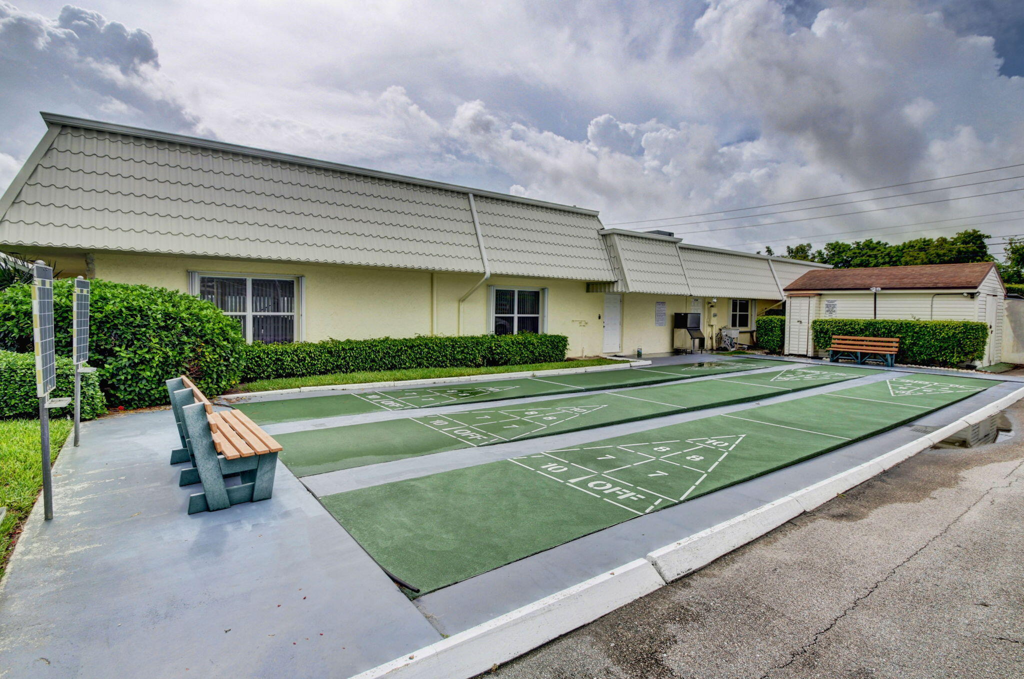 1411 Southwest 27th Avenue, Unit 201 Delray Beach, FL 33445 - Photo 48 of 48 a house view with a sitting space garden and bench