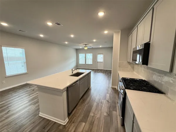 a kitchen with stainless steel appliances granite countertop a stove a sink and a refrigerator