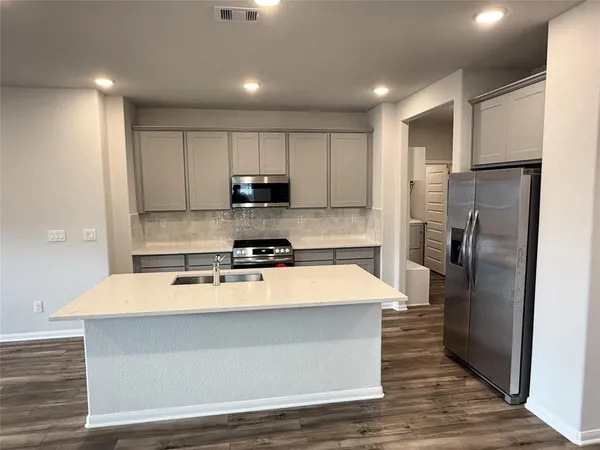 a large kitchen with stainless steel appliances and a refrigerator