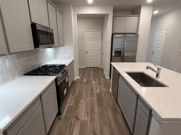 a kitchen with sink a microwave and refrigerator