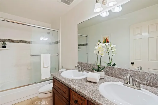 a bathroom with a granite countertop sink a toilet and a large mirror