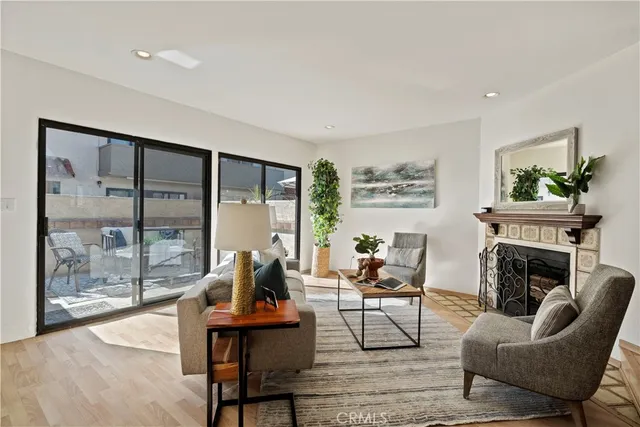 a living room with furniture a fireplace and a floor to ceiling window