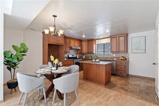 a dining room with furniture a chandelier and kitchen view