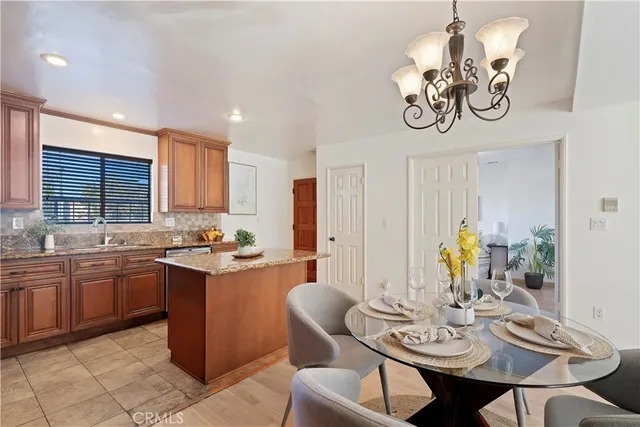a view of a dining room with furniture a chandelier and wooden floor
