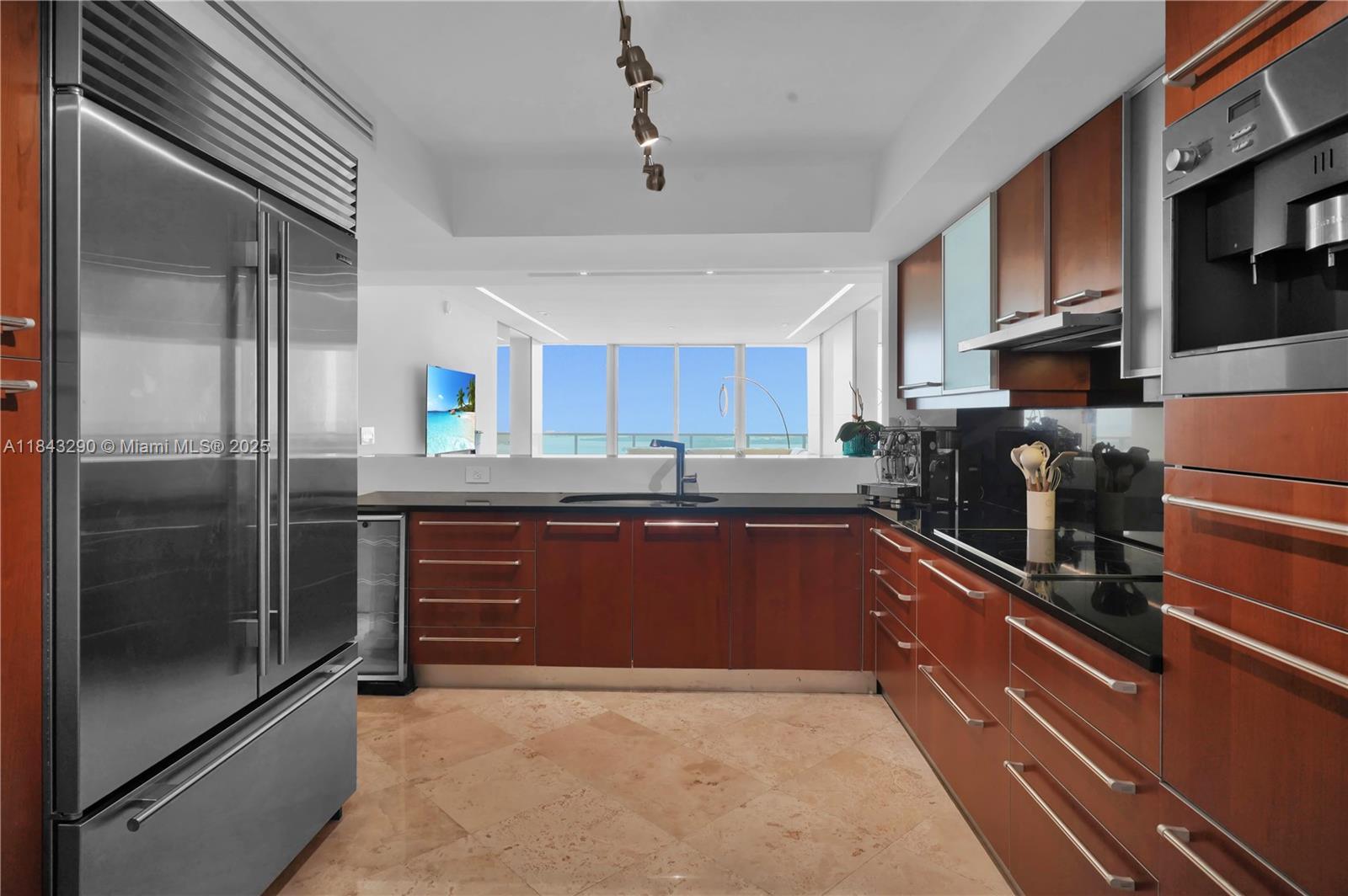 1331 Brickell Bay Drive, Unit 4303 Miami, FL 33131 - Photo 17 of 41 a kitchen with stainless steel appliances granite countertop a refrigerator a stove and a sink with wooden cabinets