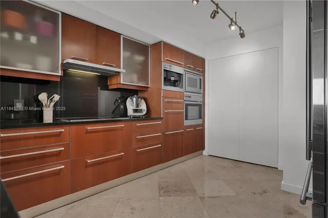 a kitchen with stainless steel appliances granite countertop a sink stove and cabinets