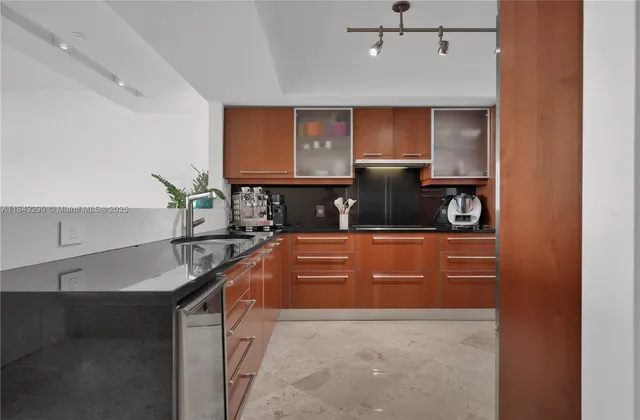 a kitchen with stainless steel appliances granite countertop a refrigerator and a stove top oven