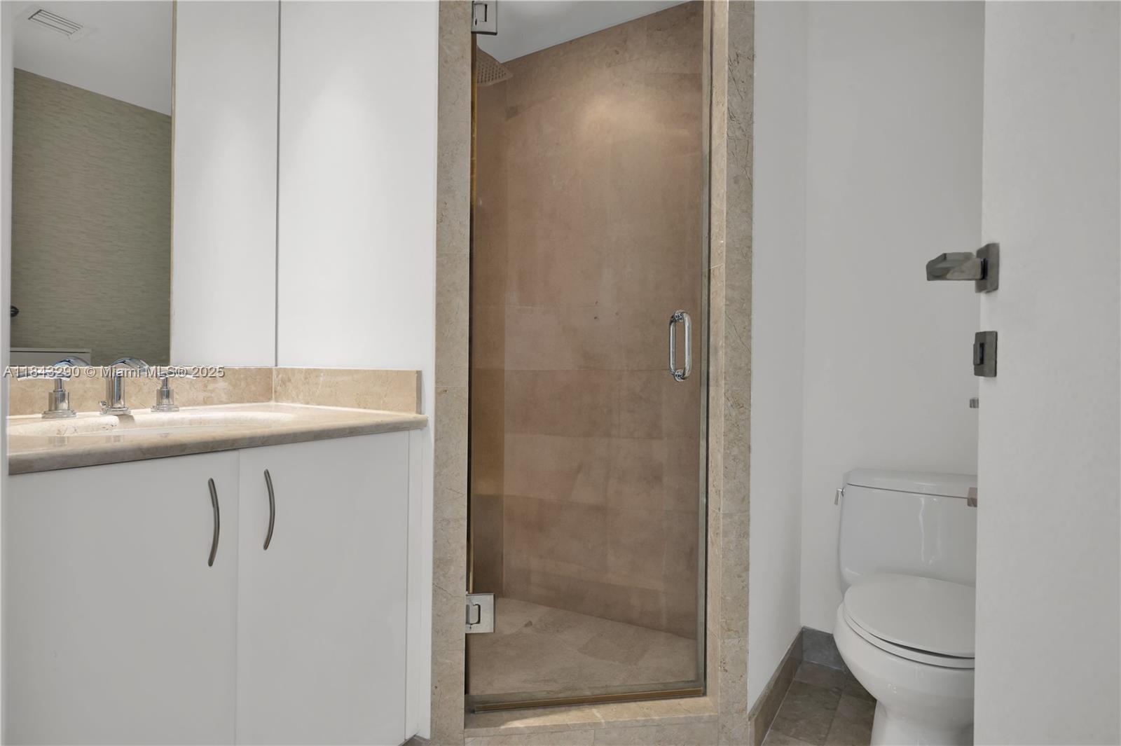 1331 Brickell Bay Drive, Unit 4303 Miami, FL 33131 - Photo 22 of 41 a bathroom with a shower sink vanity and toilet