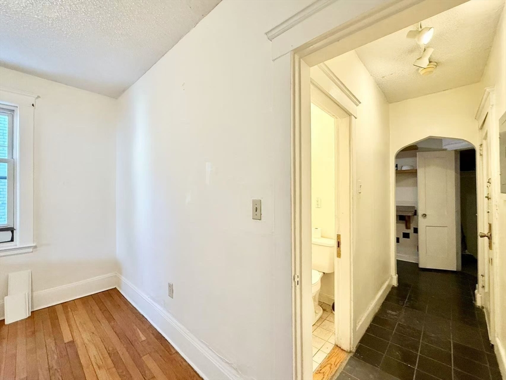 26 Chiswick Road, Unit 6 Boston, MA 02135 - Photo 5 of 19 a view of a hallway with wooden floor and a bathroom