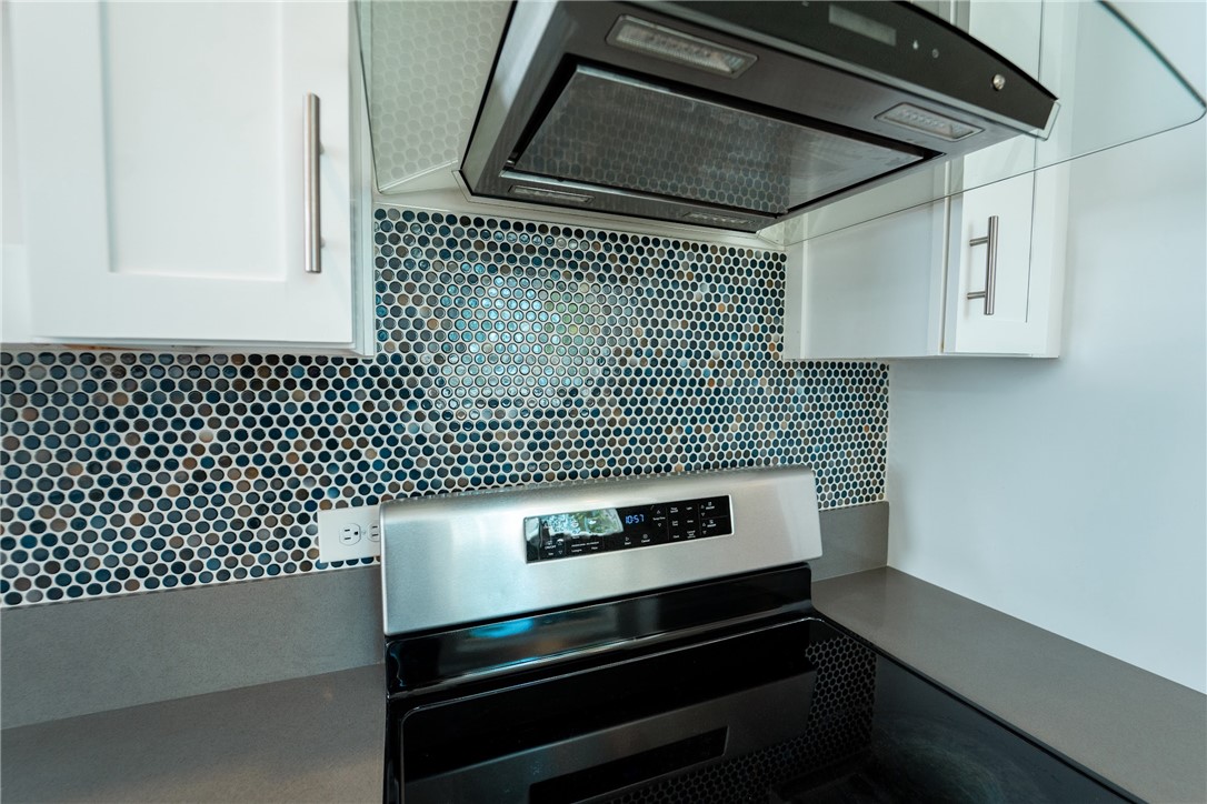 1985 Laguna Road Mohave Valley, AZ 86440 - Photo 13 of 83 Kitchen featuring white cabinetry, a circular mosaic tile backsplash, a stainless steel range, and a matching range hood