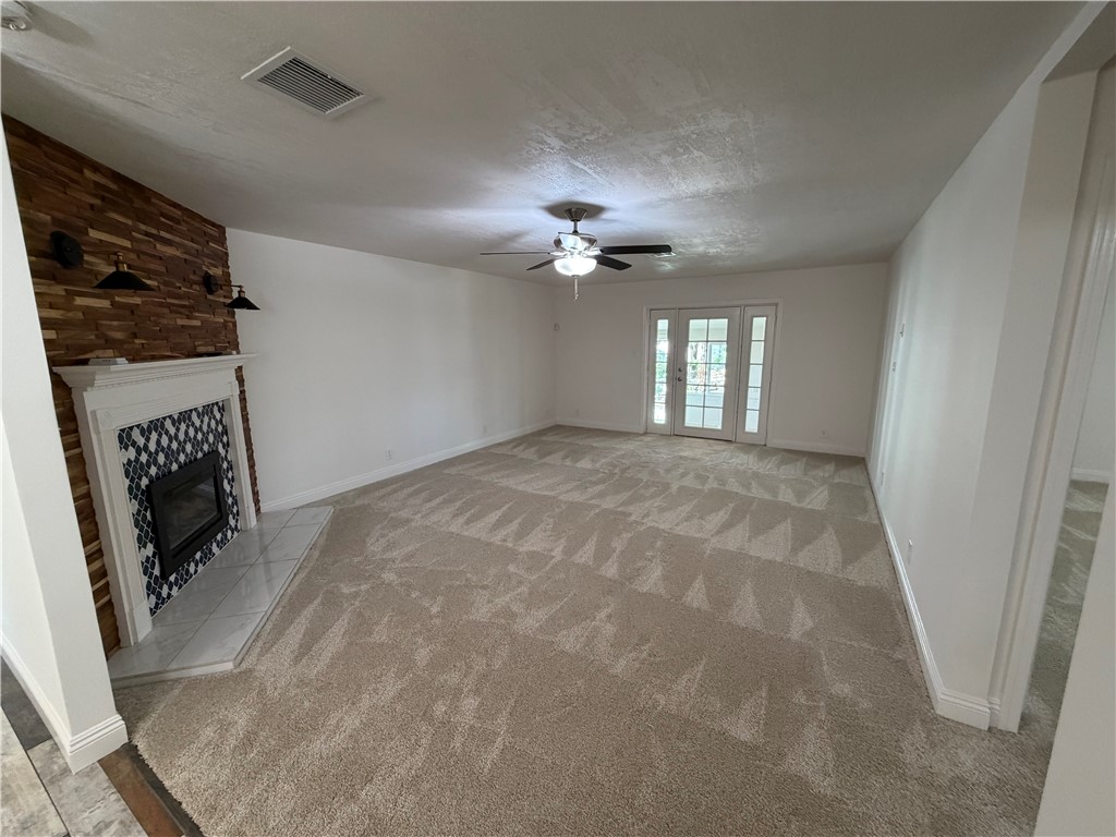 1985 Laguna Road Mohave Valley, AZ 86440 - Photo 20 of 83 Unfurnished living room featuring a fireplace, a ceiling fan, and light colored carpet