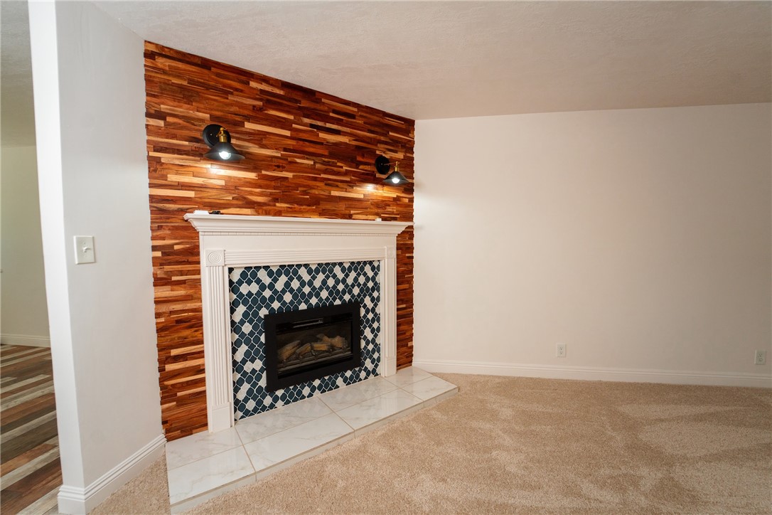 1985 Laguna Road Mohave Valley, AZ 86440 - Photo 22 of 83 The living area features a fireplace with a white mantel, blue and white patterned tile surround, and a hearth with white tiles