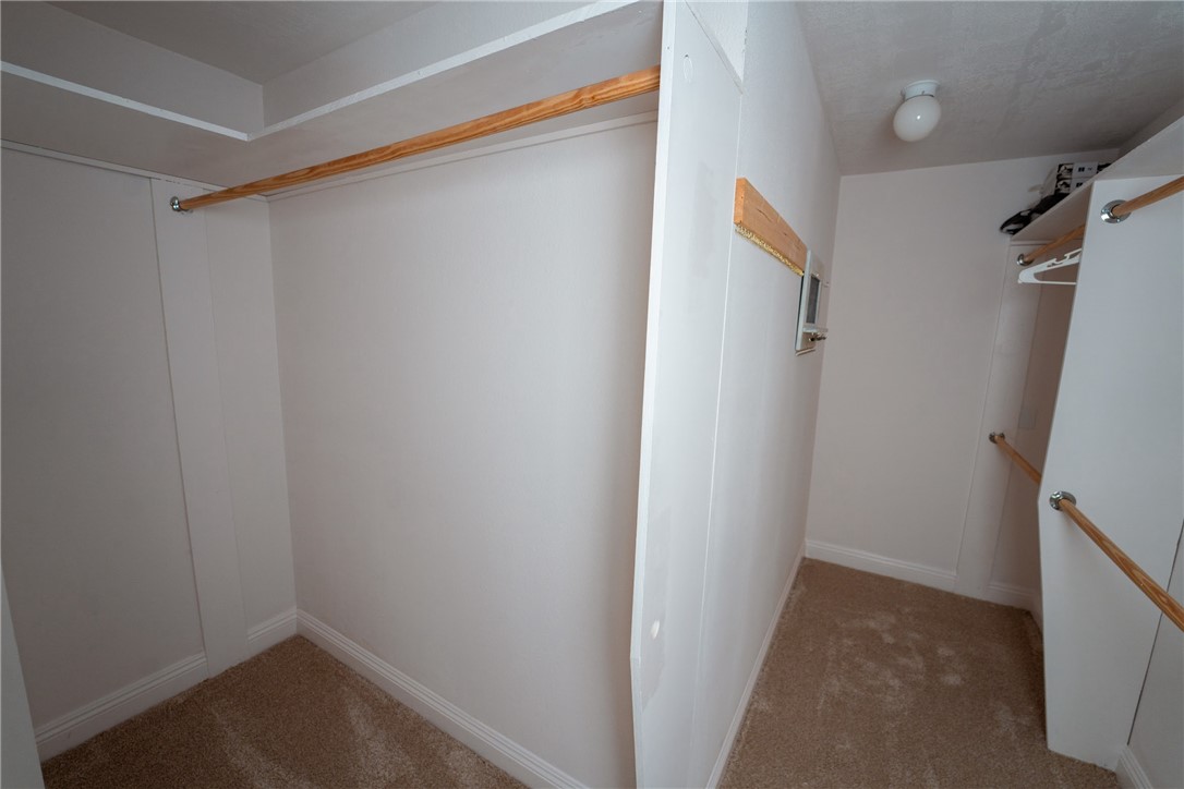 1985 Laguna Road Mohave Valley, AZ 86440 - Photo 26 of 83 The property includes a walk-in closet with carpeted flooring, white walls, and wooden hanging rods