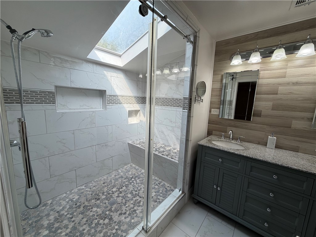 1985 Laguna Road Mohave Valley, AZ 86440 - Photo 27 of 83 Bathroom with a stall shower, vanity, a skylight, tile walls.
