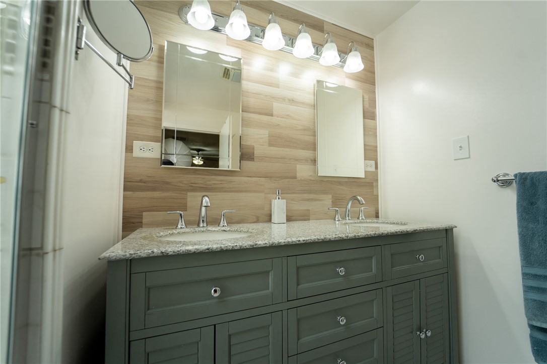 1985 Laguna Road Mohave Valley, AZ 86440 - Photo 33 of 83 Bathroom vanity featuring a light-colored granite countertop, dual sinks, and a large mirror with integrated lighting