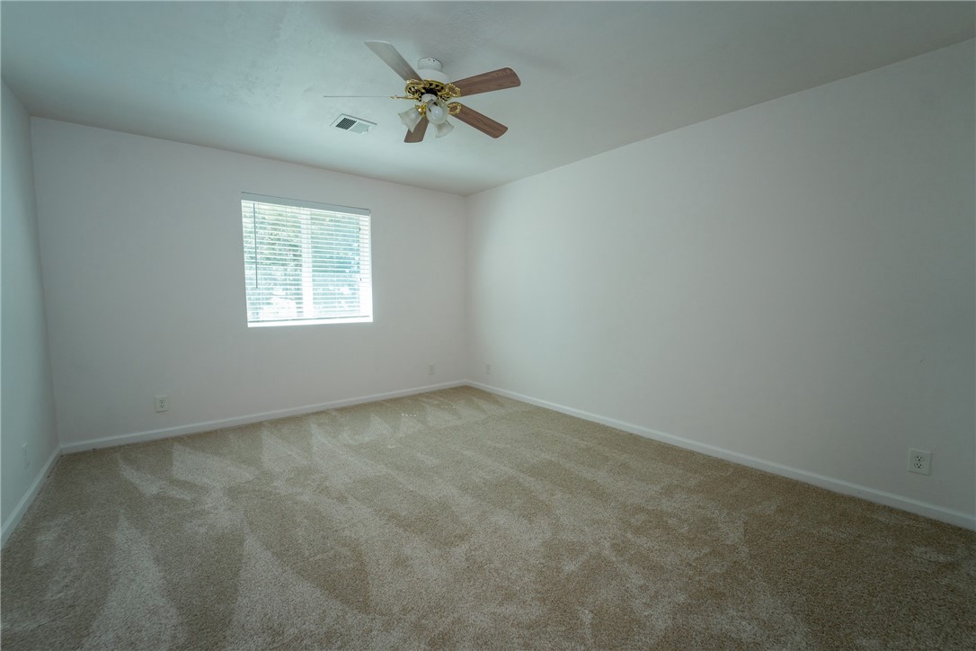 1985 Laguna Road Mohave Valley, AZ 86440 - Photo 37 of 83 This room features neutral-toned carpet, white walls, a window with blinds, and a ceiling fan with a light fixture