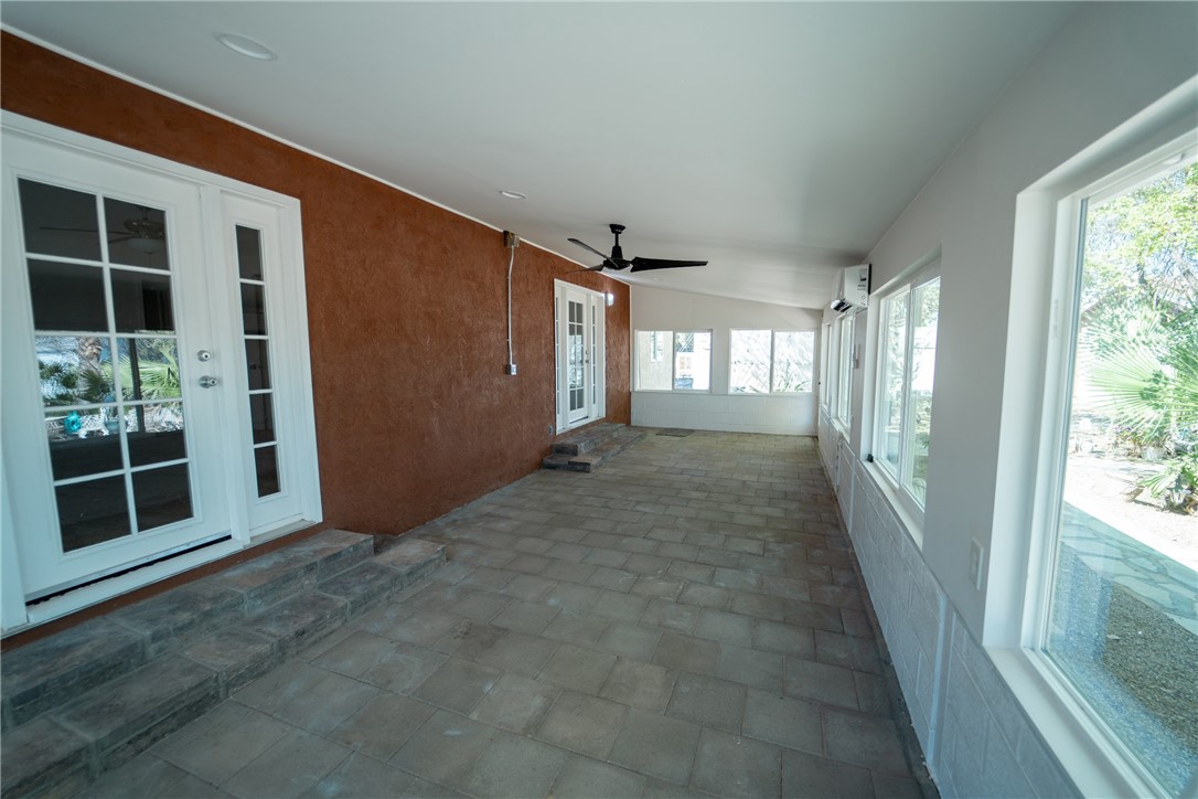 1985 Laguna Road Mohave Valley, AZ 86440 - Photo 52 of 83 The property features an enclosed patio with a paved floor, a ceiling fan, and multiple windows providing views of the exterior