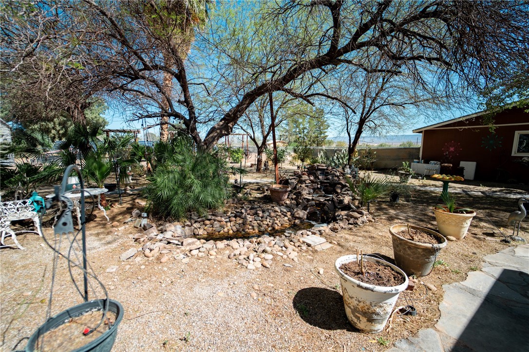 1985 Laguna Road Mohave Valley, AZ 86440 - Photo 54 of 83 The property features a landscaped yard with a rock water feature and mature trees, offering a serene outdoor environment