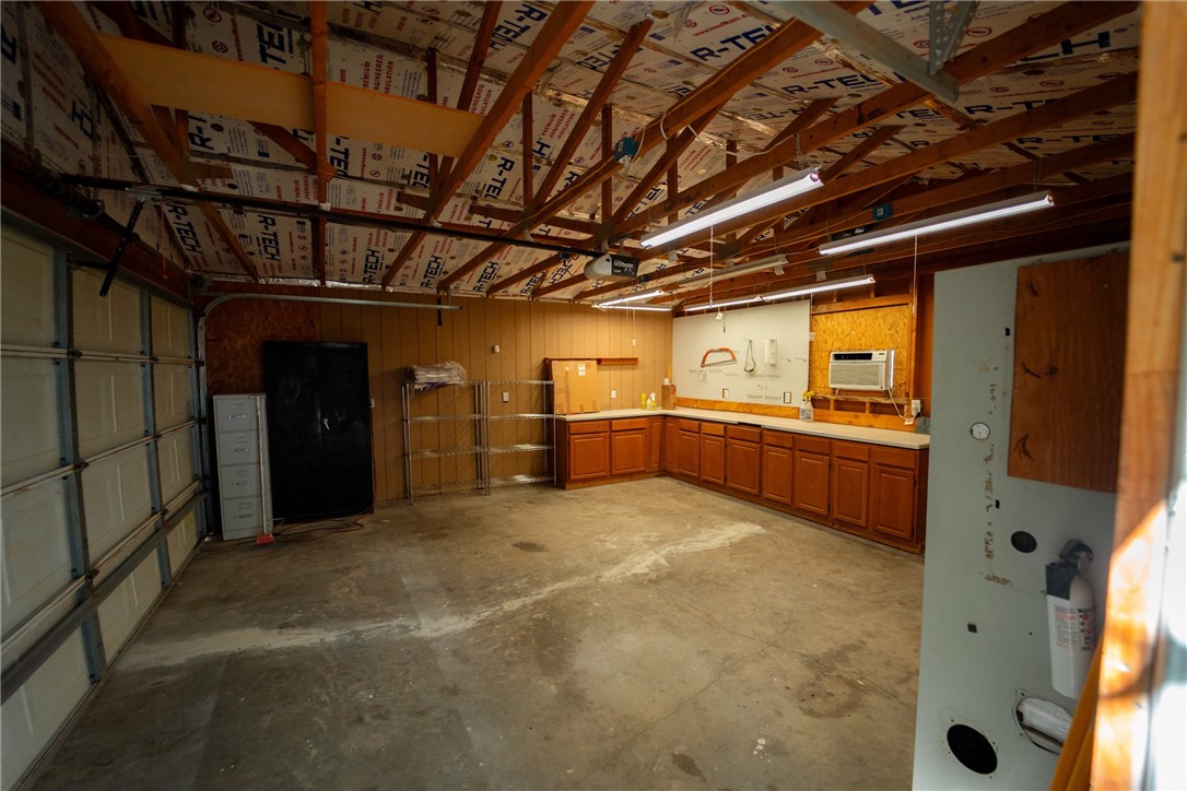 1985 Laguna Road Mohave Valley, AZ 86440 - Photo 65 of 83 Spacious garage with a concrete floor, exposed wooden beams, and extensive built-in cabinetry with countertops