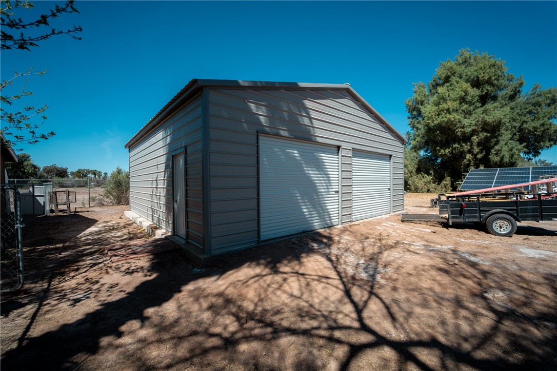 1985 Laguna Road Mohave Valley, AZ 86440 - Photo 77 of 83 The property features a metal-sided outbuilding with two roll-up garage doors and a side access door