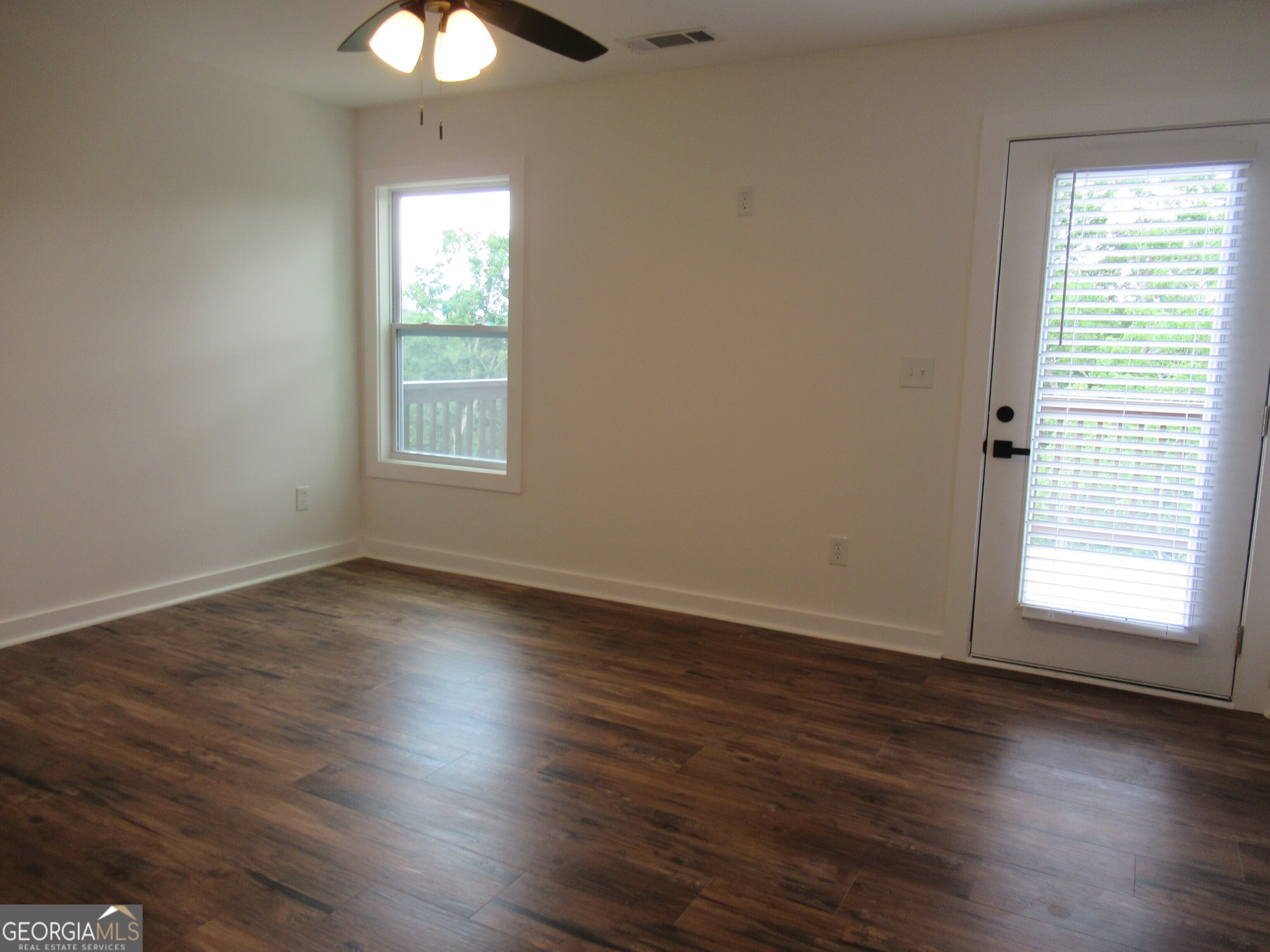 765 Old Kerns Road Dawsonville, GA 30534 - Photo 20 of 36 an empty room with wooden floor and windows