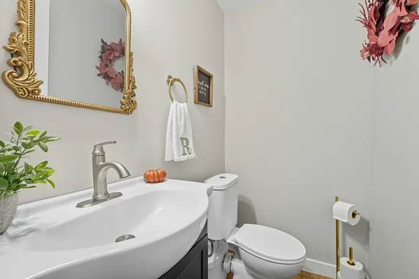 a bathroom with a sink vanity mirror and toilet