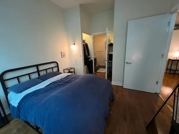 a bedroom with a bed and wooden floor