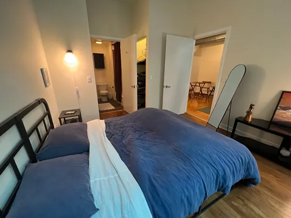 a bedroom with a bed and wooden floor