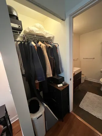 a view of walk in closet with clothes and shoes
