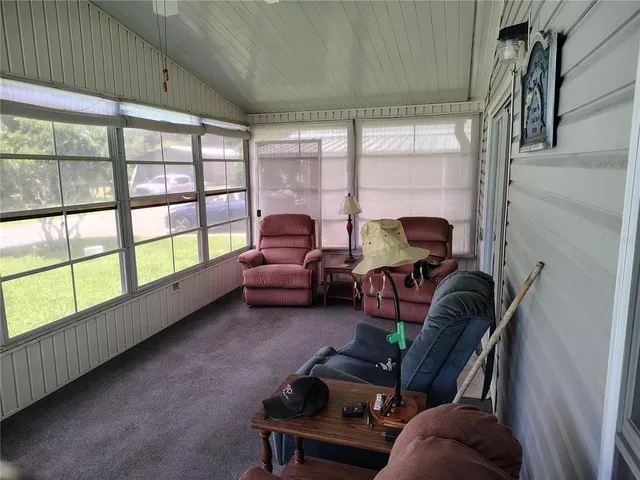 a living room with furniture a dining table and a chandelier