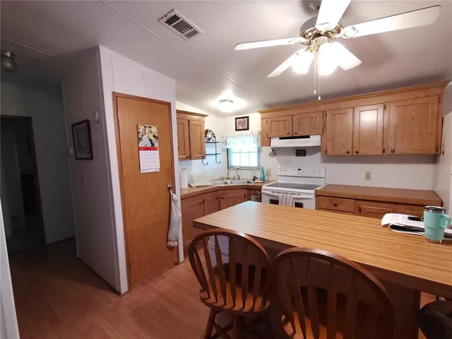 a living room with furniture a chandelier and a dining table