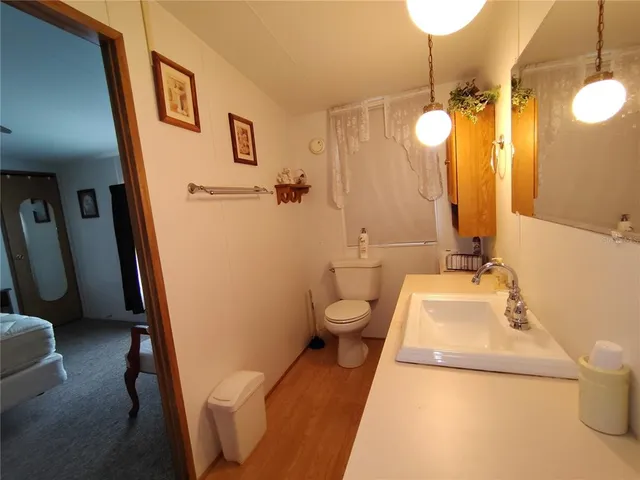 a kitchen with stainless steel appliances granite countertop a refrigerator a sink dishwasher a stove and white countertops with wooden floor