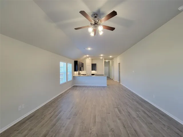 a view of a livingroom with a ceiling fan and wooden floor