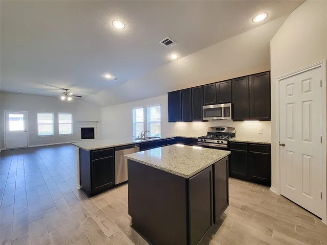 a kitchen with stainless steel appliances granite countertop a sink stove and refrigerator