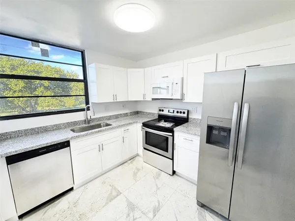 a kitchen with a refrigerator stove and sink