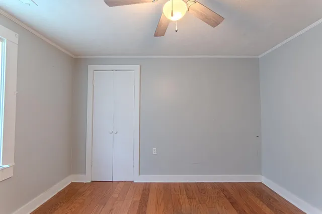 an empty room with wooden floor and cabinet