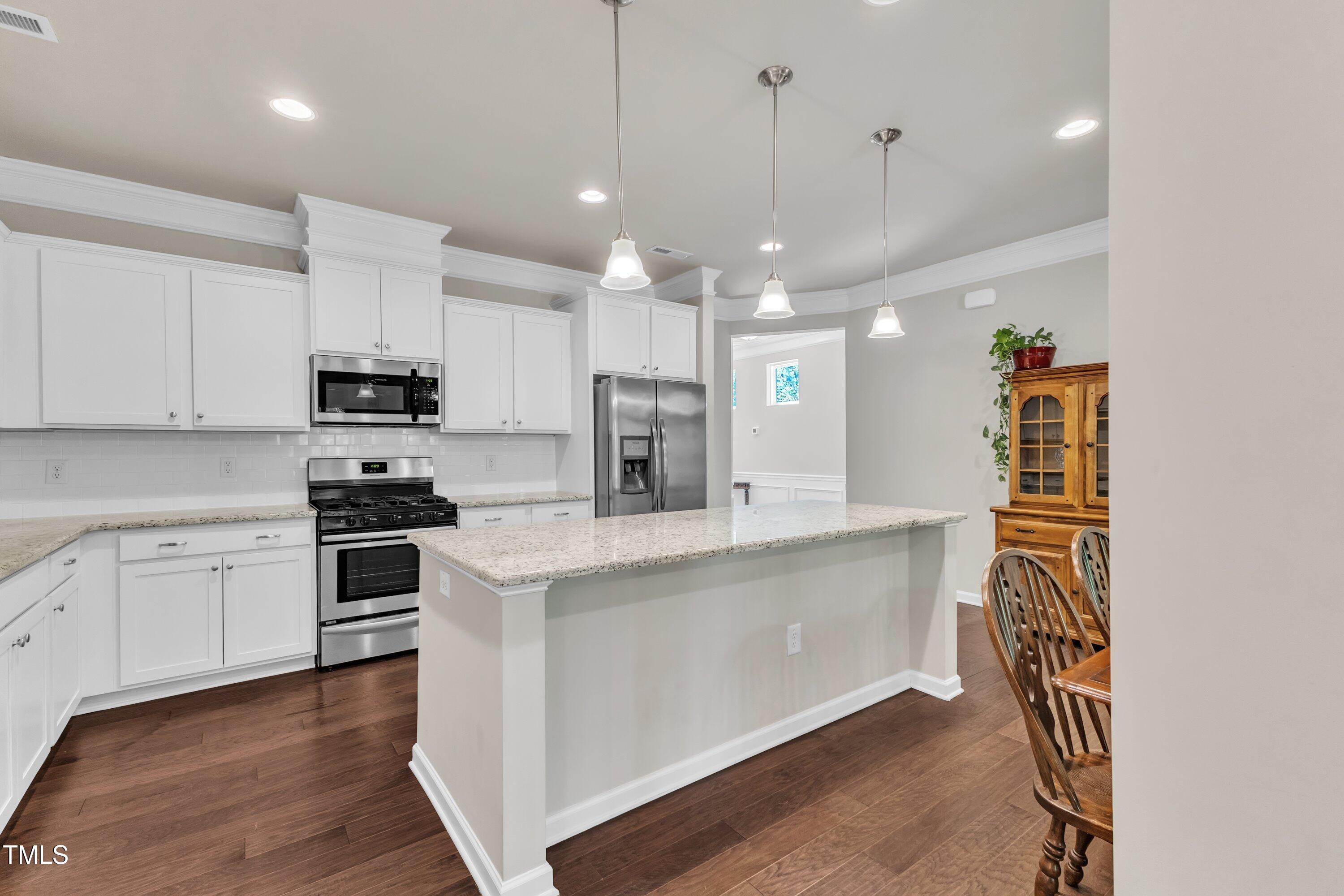 1230 Wingstem Place Raleigh, NC 27607 - Photo 11 of 41 a large kitchen with cabinets wooden floor and stainless steel appliances