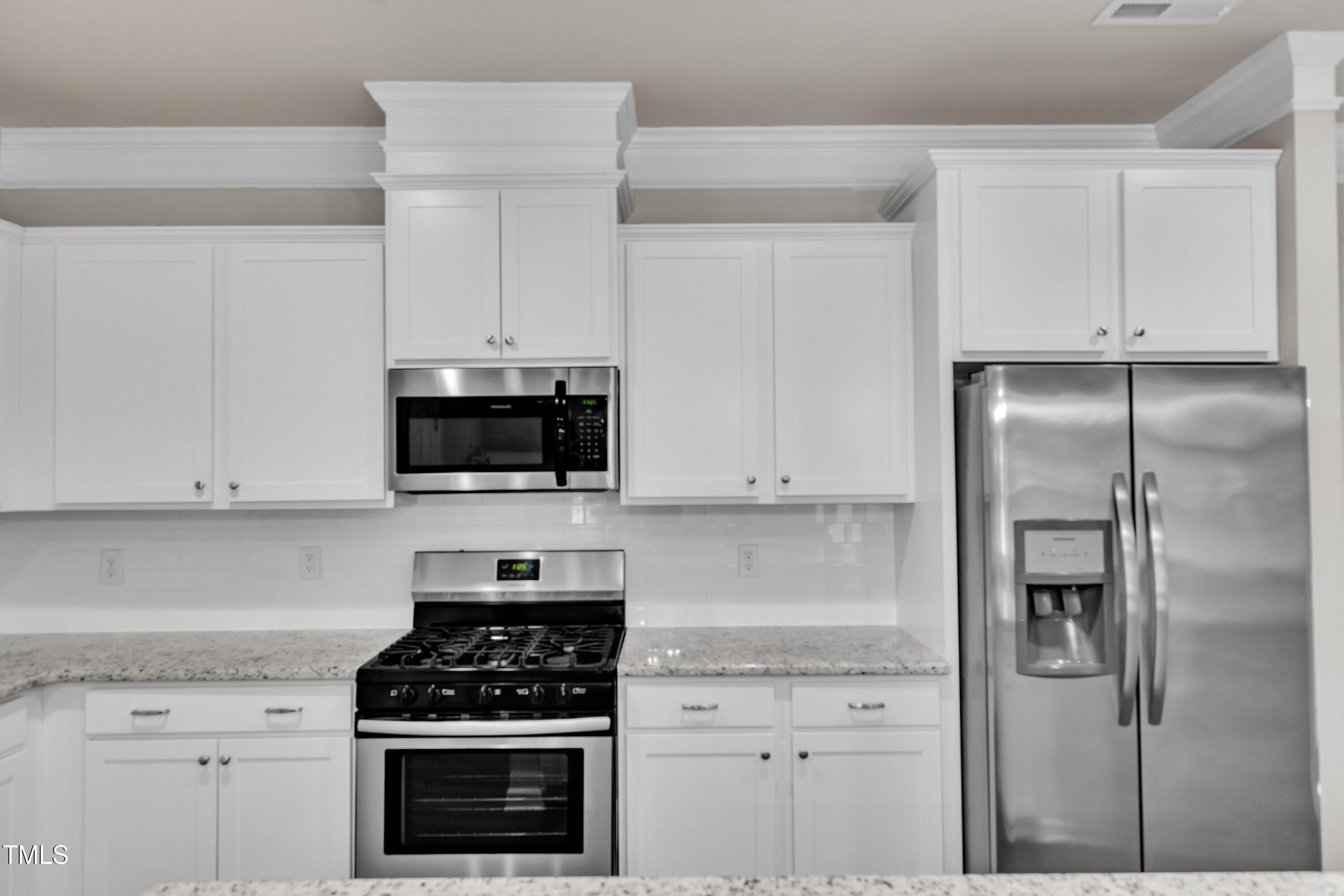 1230 Wingstem Place Raleigh, NC 27607 - Photo 13 of 41 a kitchen with white cabinets and appliances