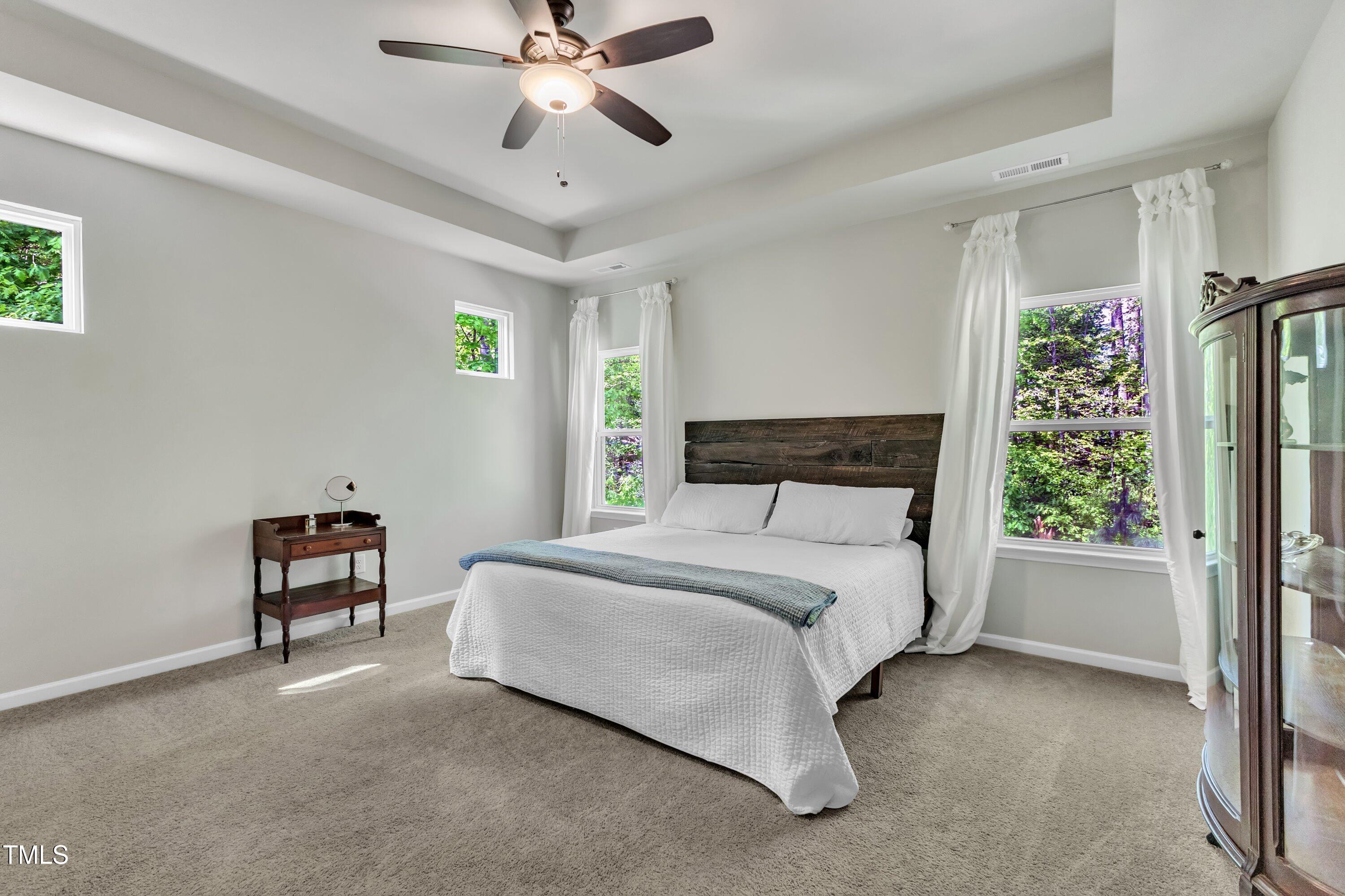 1230 Wingstem Place Raleigh, NC 27607 - Photo 22 of 41 a bedroom with a bed and a chandelier