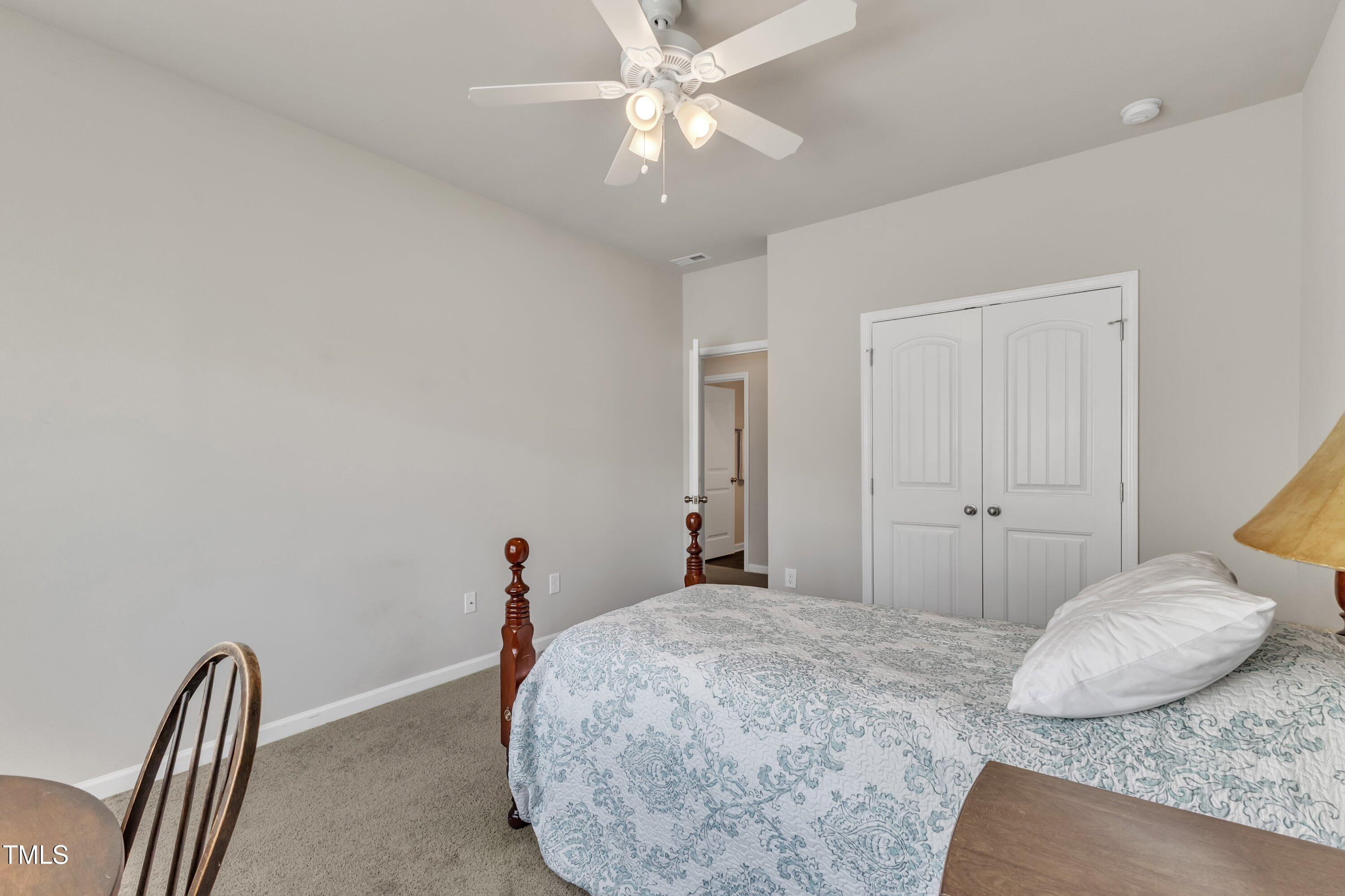 1230 Wingstem Place Raleigh, NC 27607 - Photo 31 of 41 a bedroom with a bed and a chandelier