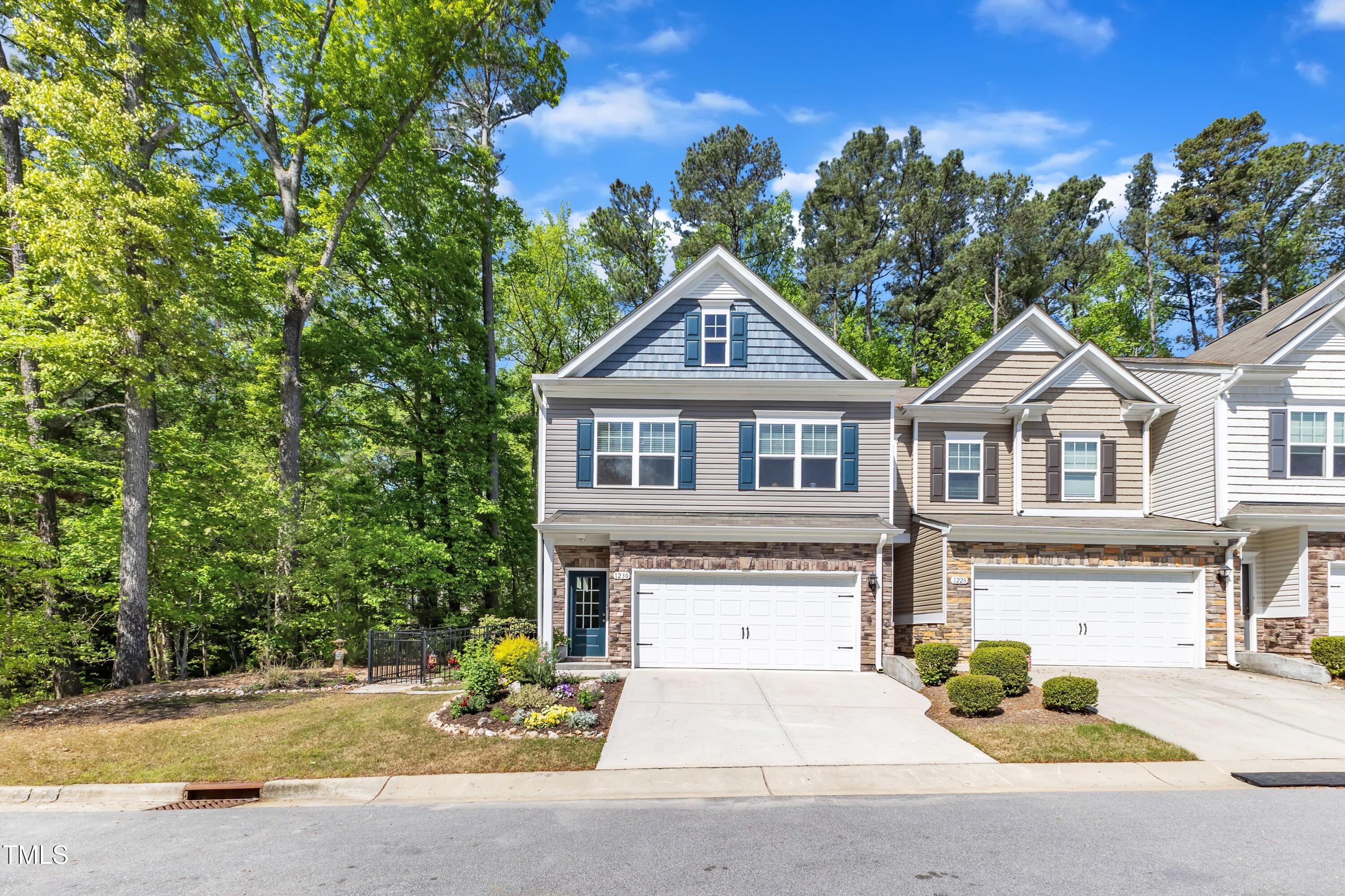 1230 Wingstem Place Raleigh, NC 27607 - Photo 4 of 41 a front view of a house with a yard and garage