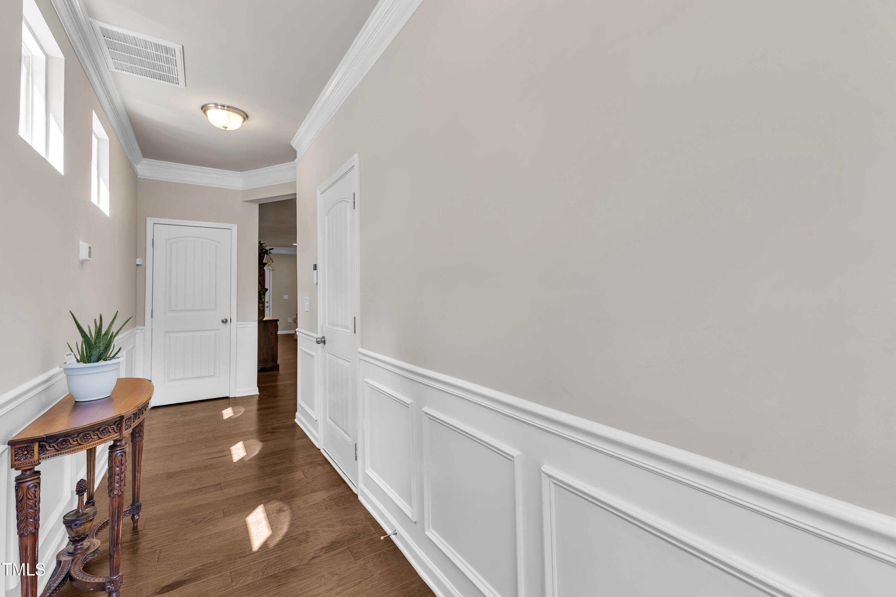 1230 Wingstem Place Raleigh, NC 27607 - Photo 8 of 41 a view of a hallway to a livingroom with furniture and wooden floor