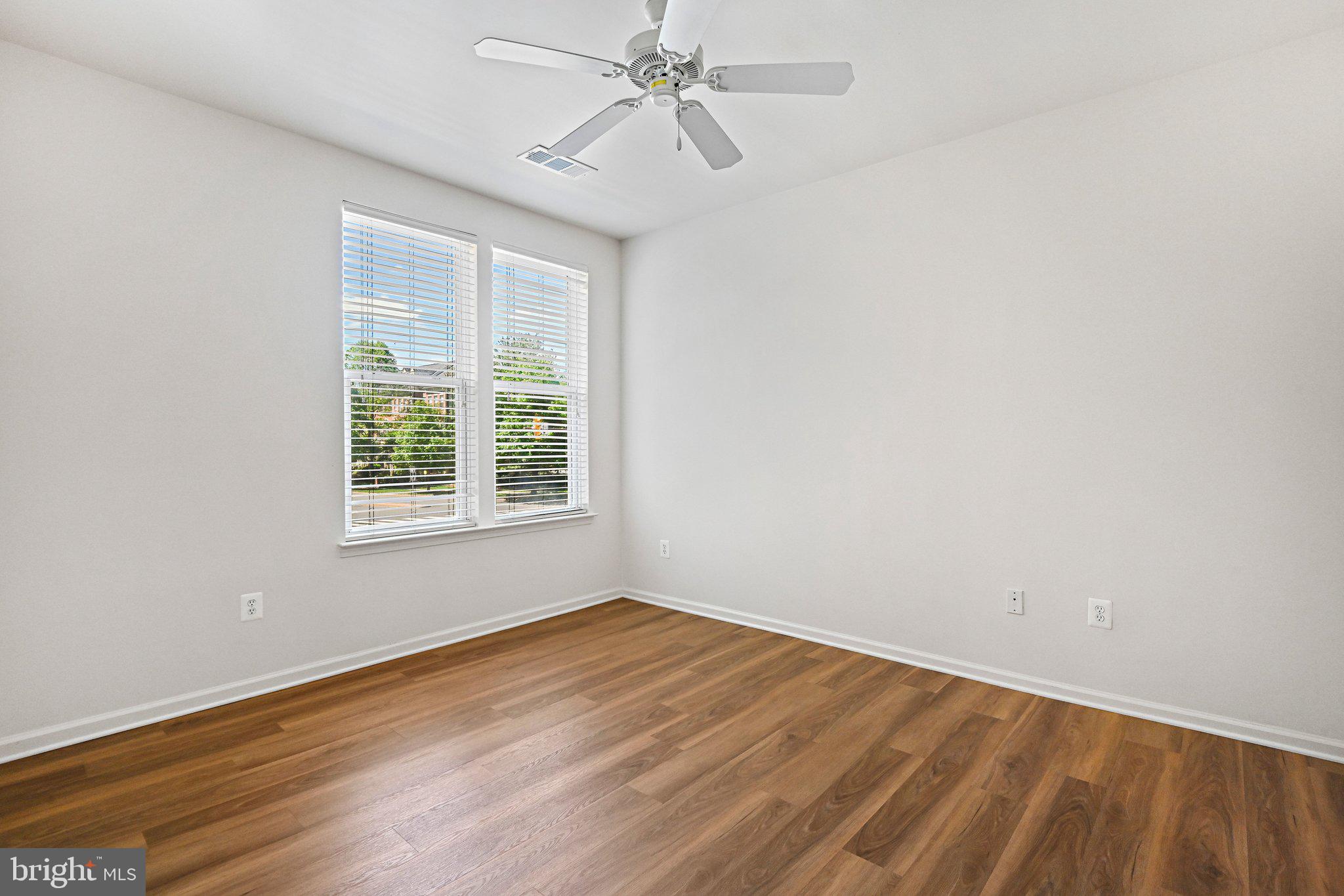 12001 Market Street, Unit 151 Reston, VA 20190 - Photo 11 of 25 wooden floor in an empty room with a window