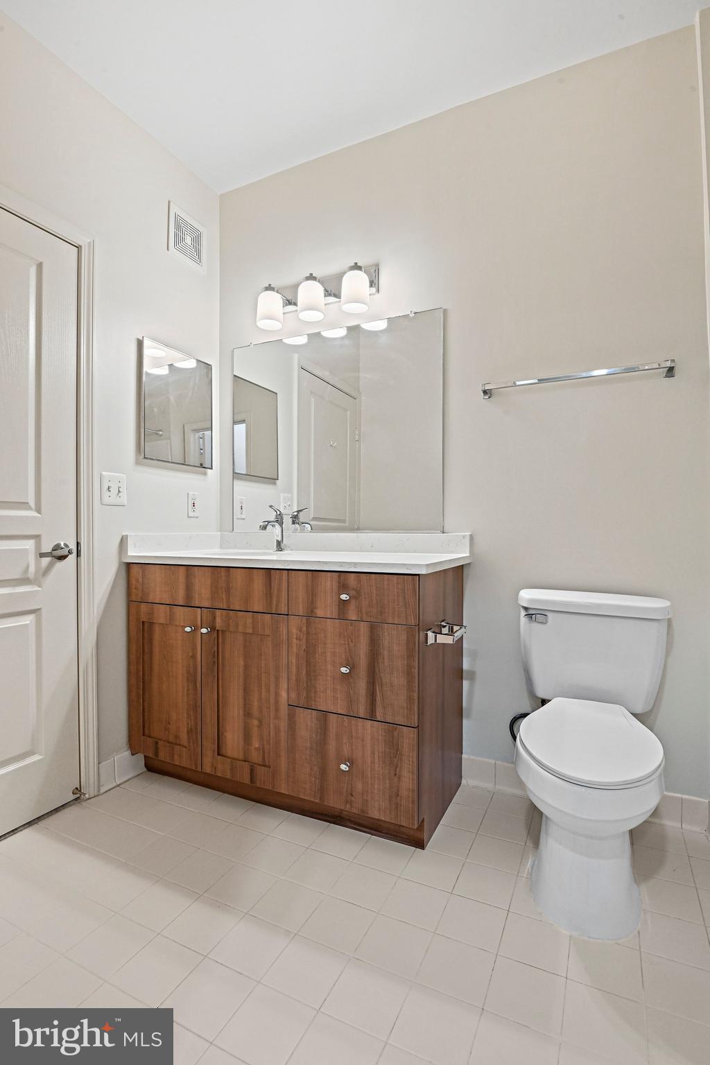 12001 Market Street, Unit 151 Reston, VA 20190 - Photo 17 of 25 a bathroom with a sink a toilet and mirror