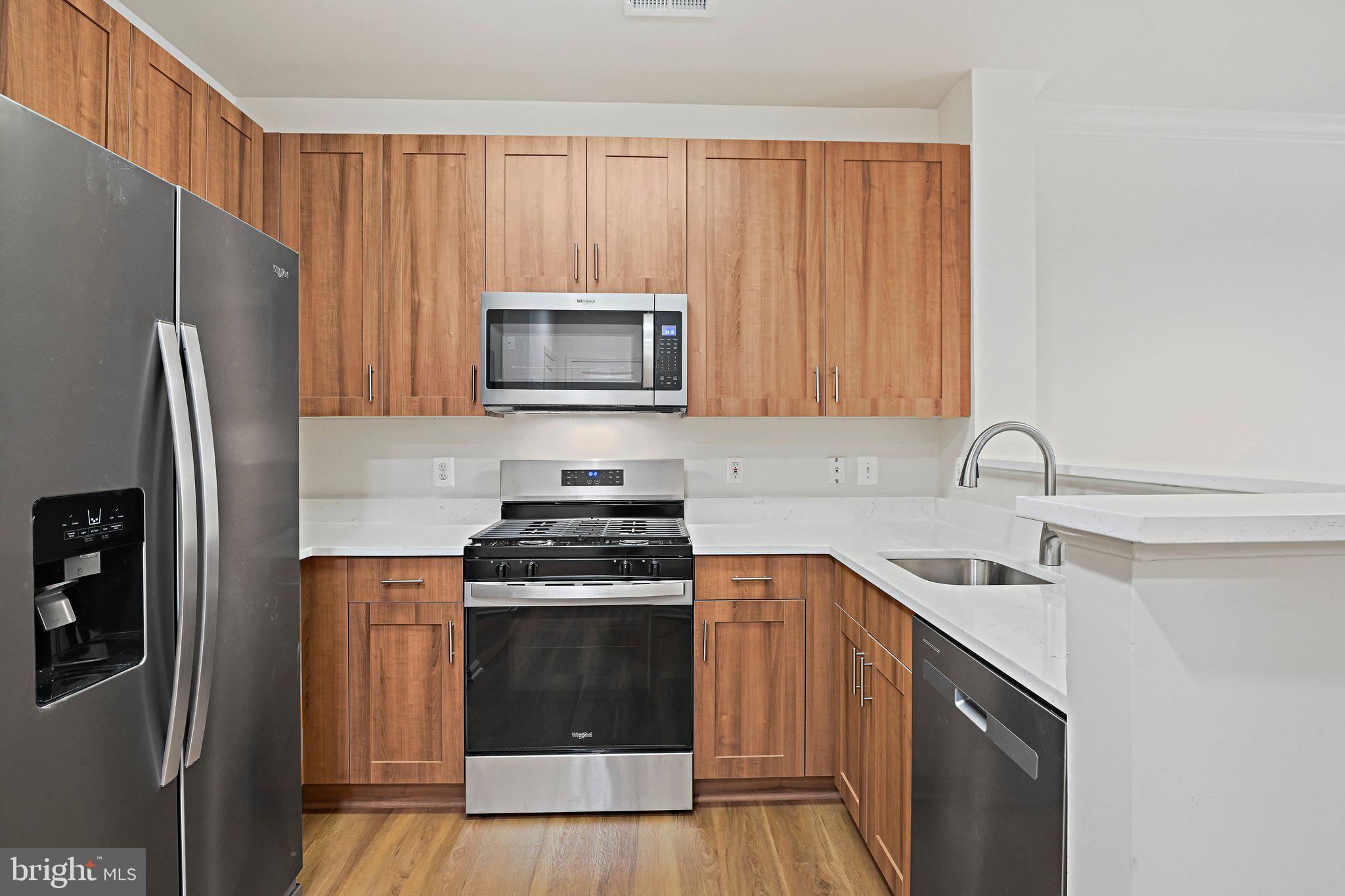 12001 Market Street, Unit 151 Reston, VA 20190 - Photo 4 of 25 a kitchen with a sink stove and refrigerator
